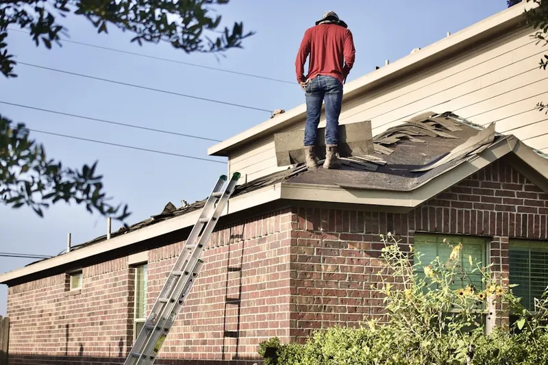 Professional roofer working on a residential roof in Weatherly Woods